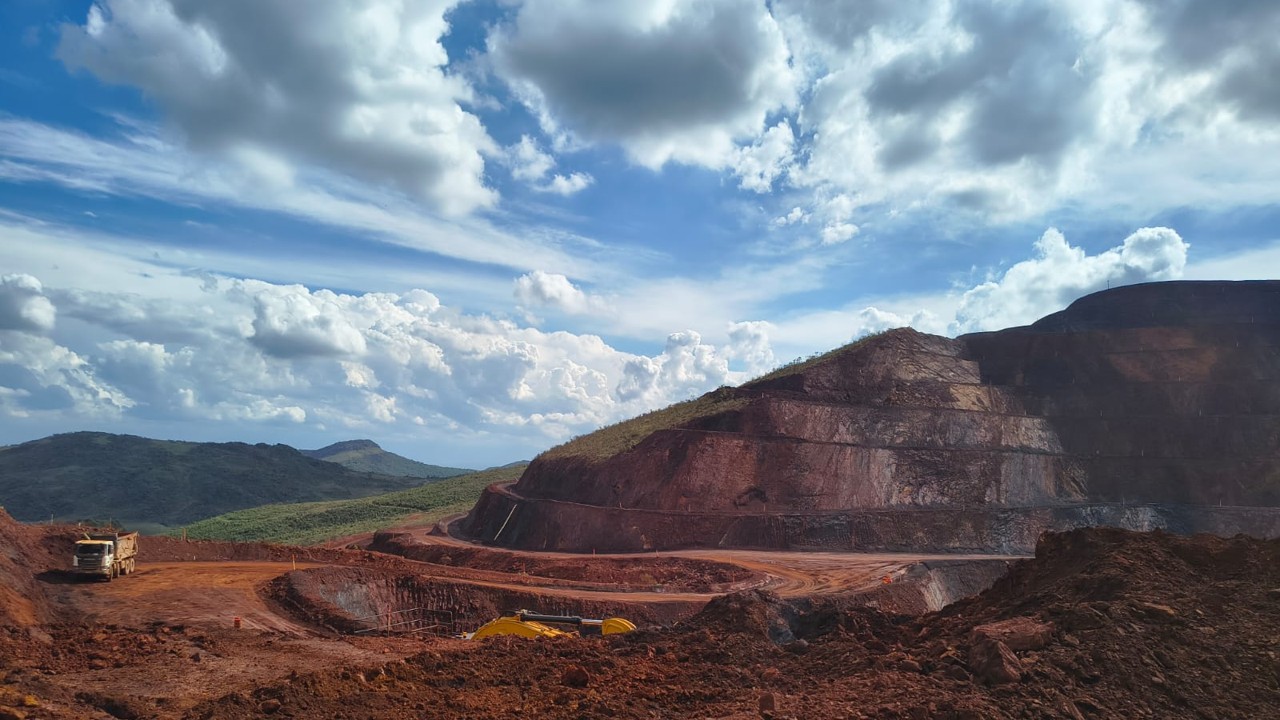 Cava de mineração a céu aberto com bancadas e caminhão fora de estrada